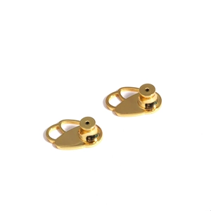 Detailed view of two gold metal earring lifters for earlobe support and stability