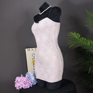 Detalle de mini vestido ajustado de encaje que muestra patrones florales y silueta ceñida