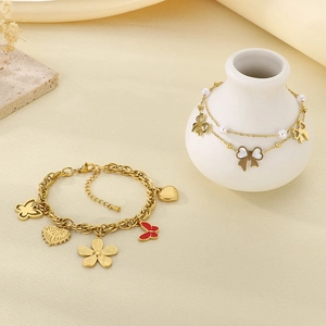 Detail view of 18K gold plated charm bracelets with butterfly and heart pendants