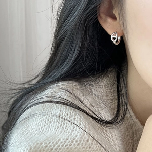 Minimalist silver pig nose link hoop earrings for women shown worn on a model's ear