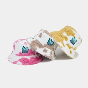 Detail of plush cow print bucket hats with Chill OUT embroidery in three trendy colors