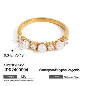Detail view of gold stainless steel ring with white pearl and sparkling zircons