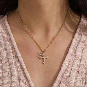 Dettaglio dei doppi ciondoli a croce in acciaio placcato oro con pavé di cristalli brillanti
