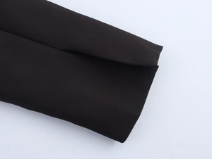 Detailed close-up showing the smooth black fabric and stitching on blazer sleeve cuff