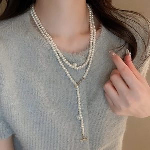 Detailed view of elegant double-layer pearl necklace featuring a golden OT toggle clasp