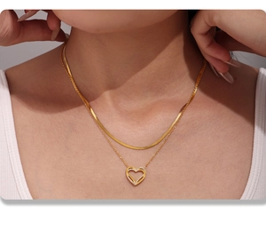Dettaglio della collana a doppio strato dorata a serpente con pendente a cuore scintillante