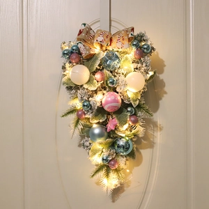 Detail of Christmas teardrop swag with LED lights and painted ornaments on door