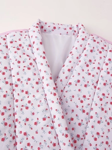 Detail of red rose floral pattern on white satin fabric with pink trim accents