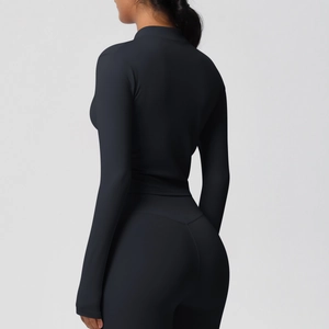 Détail des coutures ergonomiques sur la veste de yoga noire et le legging taille haute