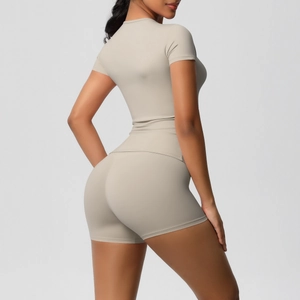 Rear view of sleek light khaki yoga set featuring tight t-shirt and high waist shorts