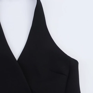 Detail view of the black halter neck and deep V-neckline on this mini blazer dress