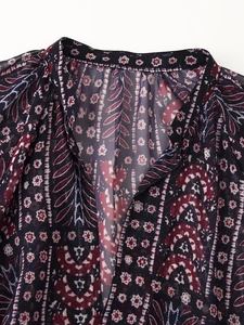 Detail of bohemian paisley print on lightweight chiffon blouse with V-neck collar
