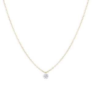 Macro detail of the gold chain necklace featuring a brilliant round-cut zircon pendant