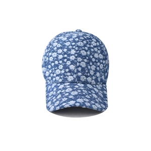 Close-up detail of denim baseball cap with white floral print and durable fabric texture
