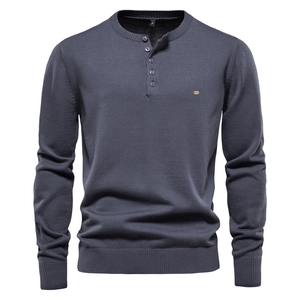 Detailed view of navy knit sweater with ribbed cuffs and four-button Henley neckline