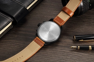 Detailed view of stainless steel watch back with brand engravings on dark wood background