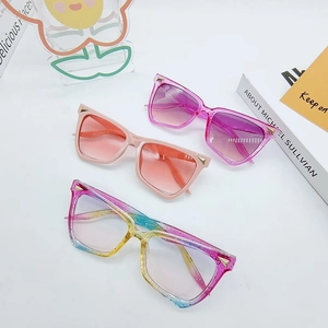 Three pairs of colorful oversized cat eye sunglasses with metallic trim on white backdrop