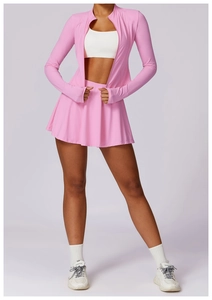 Detail van roze geplooide sportrok met hoge taille en bijpassend yoga-jack met rits