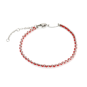 Macro detail of red string bracelet featuring polished silver beads and lobster clasp