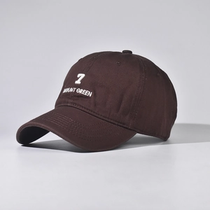 Detail of white 7 Mount Green embroidery on dark brown cotton baseball cap fabric