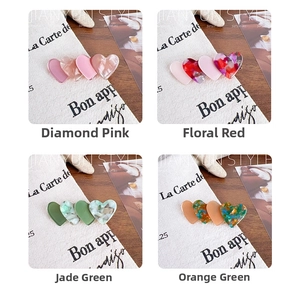 Detail view of heart-shaped acetate hair clips in four elegant color variations