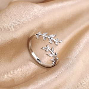Elegant adjustable silver leaf ring with zircon stones on a soft satin background