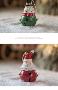 Close-up of Santa and snowman painted metal bells hanging on a festive Christmas tree