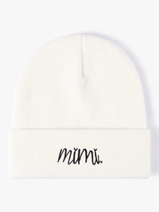 Close-up of the fine knitted texture and black mimi embroidery on a white beanie hat