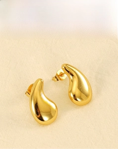 Detailed macro view of 18K gold plated teardrop earrings with a mirror polished finish