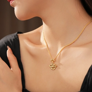 Gros plan d'un collier doré avec pendentif en forme d'éventail porté par un mannequin