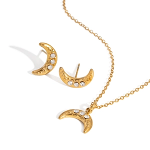 Golden moon necklace and earrings jewelry set with sparkling zircons on white background