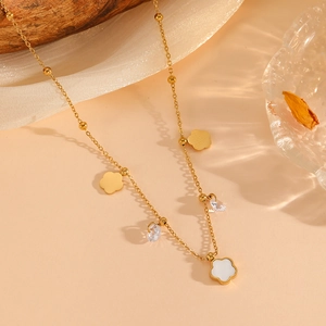 Detail of gold floral necklace with shell petals and crystals on silk background