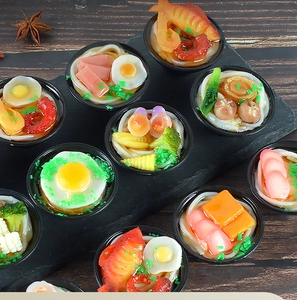 Detailed close-up of assorted mini Japanese udon and ramen bowl charms on slate