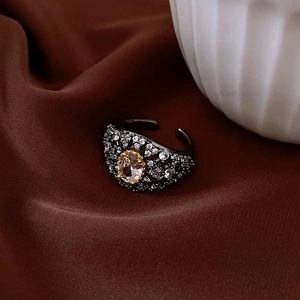 Detailed close-up of retro black-plated open ring with micro-set diamonds and champagne gem