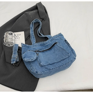 Close-up of blue denim tote bag with a small coin purse and adjustable shoulder strap
