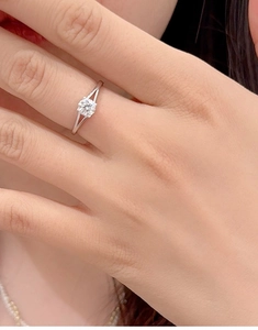Detailed close-up of a 925 silver four-prong solitaire ring worn on a finger