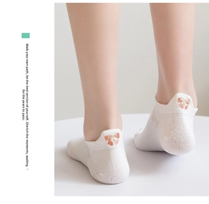 Close-up of white low-cut cotton socks featuring a pink bow embroidery on the heel