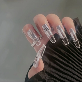 Detail view of long trapezoid nails with white outlines and black NY typography print