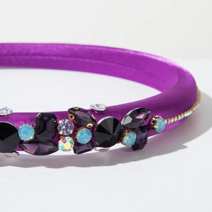 Macro detail of purple satin headband featuring sparkling colorful crystal embellishments