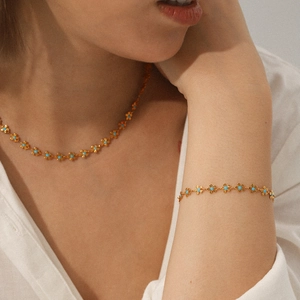Detailed view of 18K gold plated stainless steel flower necklace with green inlay