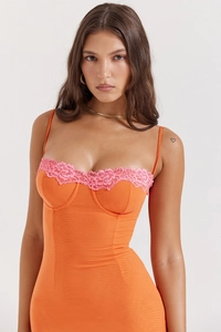 Detail der zarten rosa Spitze und des orangefarbenen Stoffes am Sommer-Bodycon-Kleid