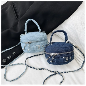 Detailed close-up of blue denim quilted mini bags with metal chain straps and buckles