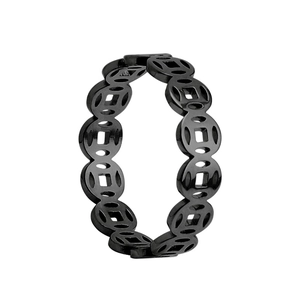 Macro shot of black titanium steel ring featuring hollowed out traditional coin pattern