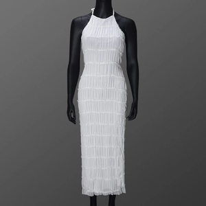 Close-up of white halter neck maxi dress featuring unique crinkled pleated fabric texture