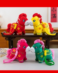 Four colorful 2026 Year of the Horse plush mascot toys displayed on a classic wooden table