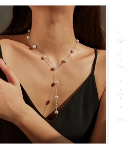 Elegant Y-shaped necklace with white pearls and silver chain shown on model neck