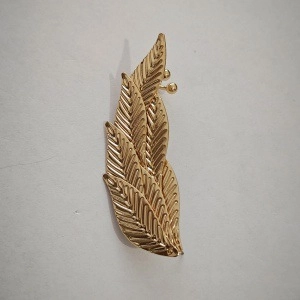 Gedetailleerde weergave van gouden oorklem met fijne bladnerven en gelaagd ontwerp