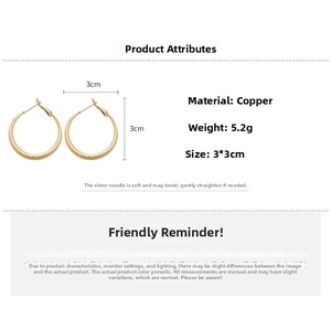 Détail de créoles dorées mates montrant le diamètre de 3cm et la finition texturée