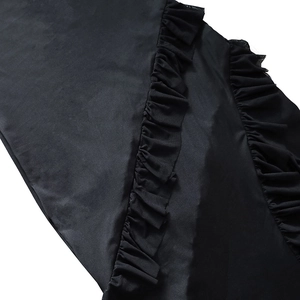 Detail of ruffle edges and pleated texture on black backless satin evening dress