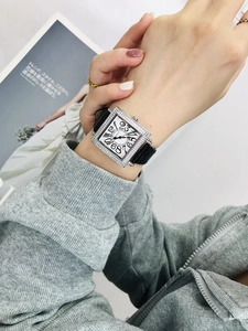 Primer plano de un reloj cuadrado con diamantes, números grandes y correa de cuero